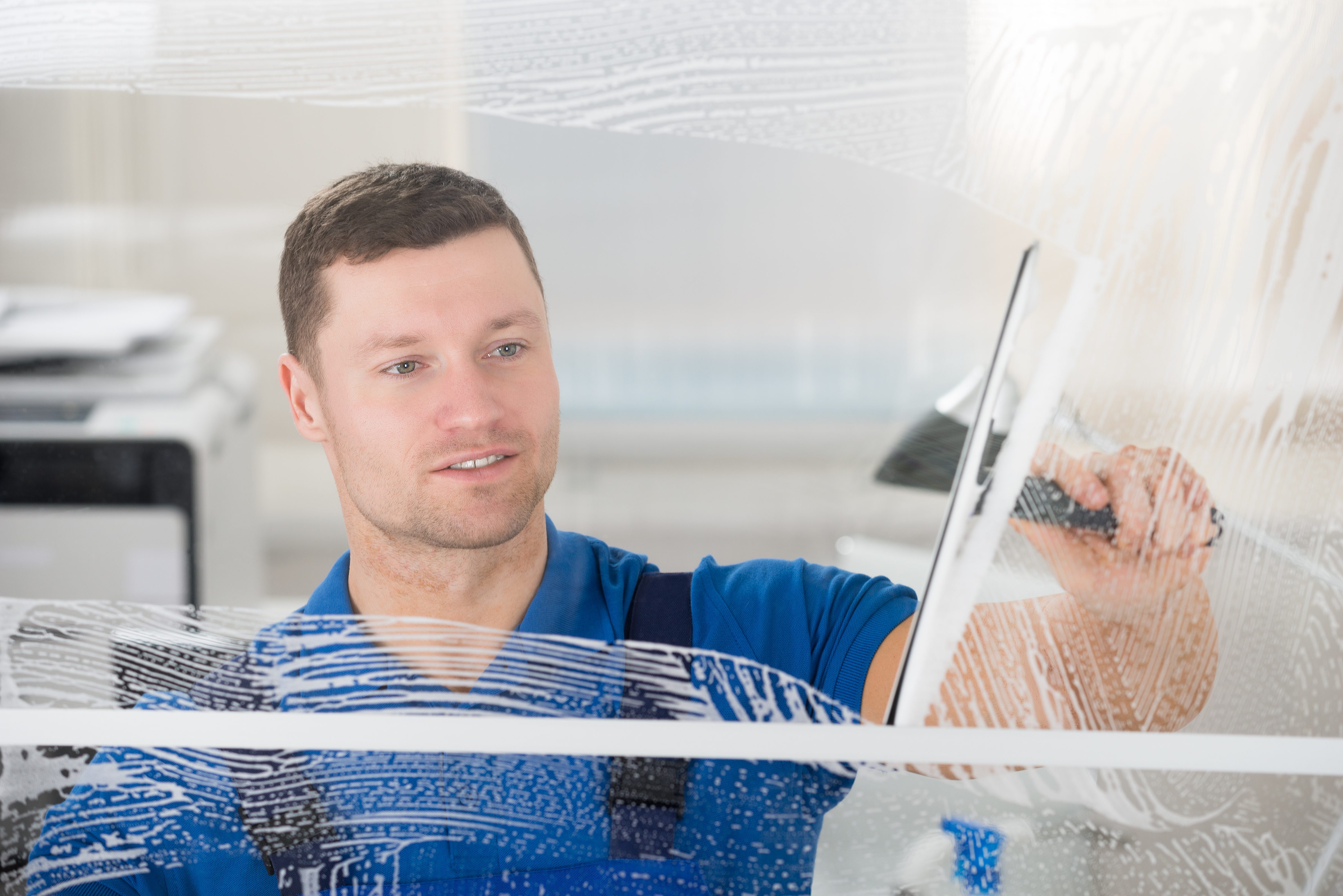 A man in blue shirt holding a window washer.